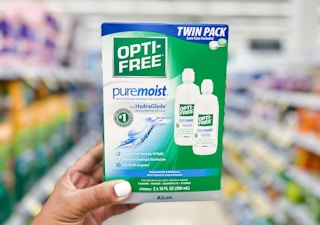 hand holding a twin-pack box of Opti-Free Multi-Purpose solution in aisle
