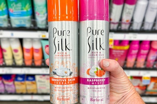 hand holding two cans of pure silk shaving cream