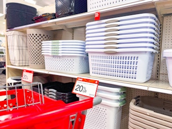 laundry baskets sitting on a target shelf with a target cart parked