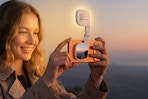Woman using the  ATDIAG Magnetic Selfie Light outdoors in the evening.