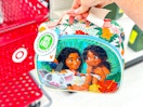 hand holding a disney princess moana lunch bag in front of a parked cart