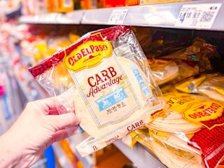 hand holding a pack of old el paso carb advantage tortillas in walmart aisle