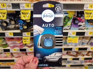 hand holding a febreze auto car clip freshener