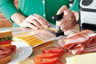A hand sealing a zipper bag of food