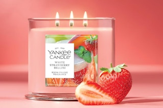 a pink candle with strawberries on a pink background