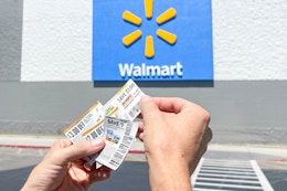 someone holding coupons outside of walmart
