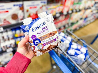 hand holding a 4-count of Ensure Max Protein shakes at Walmart