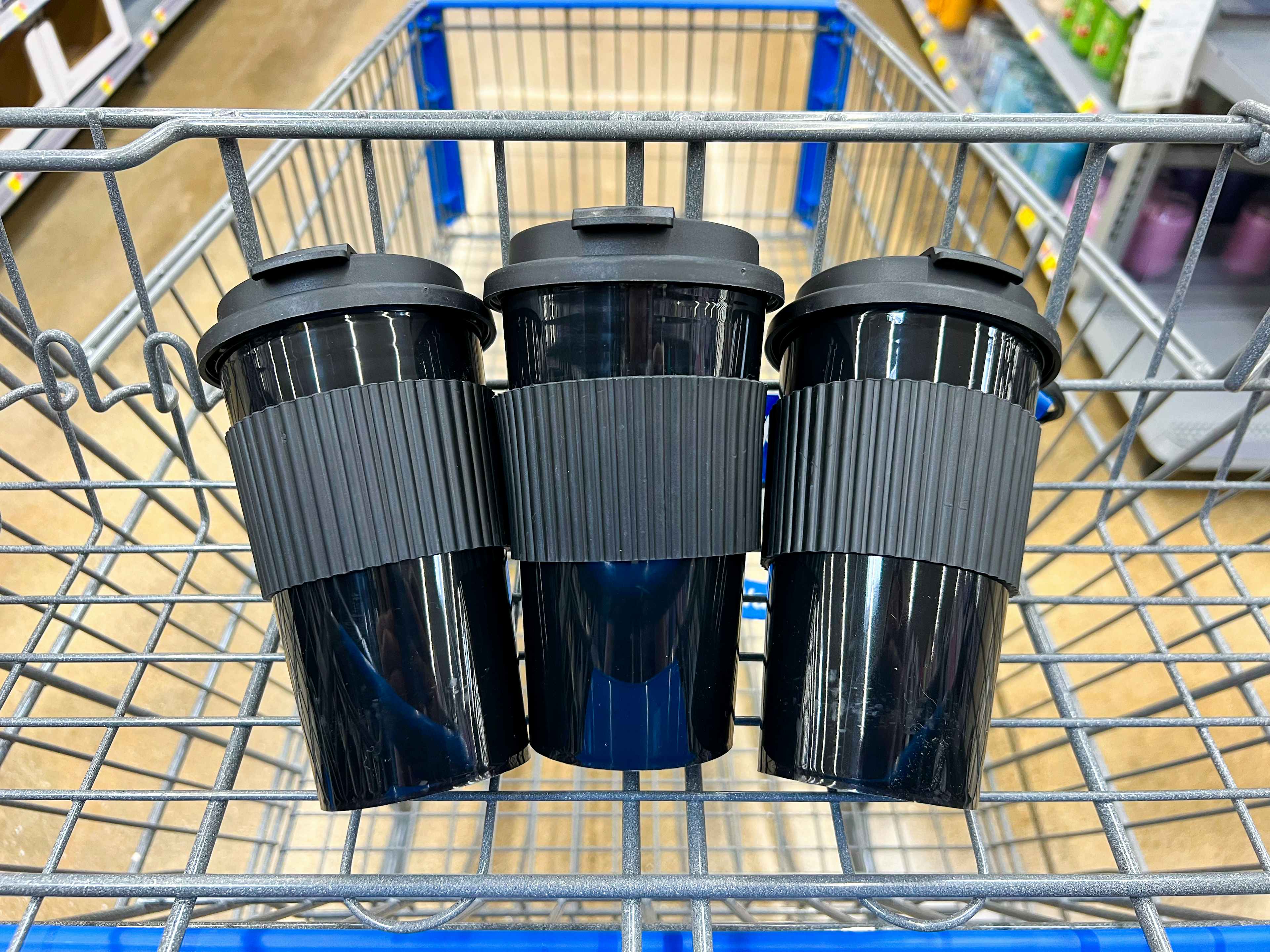 3 black reusable coffee tumblers in a cart