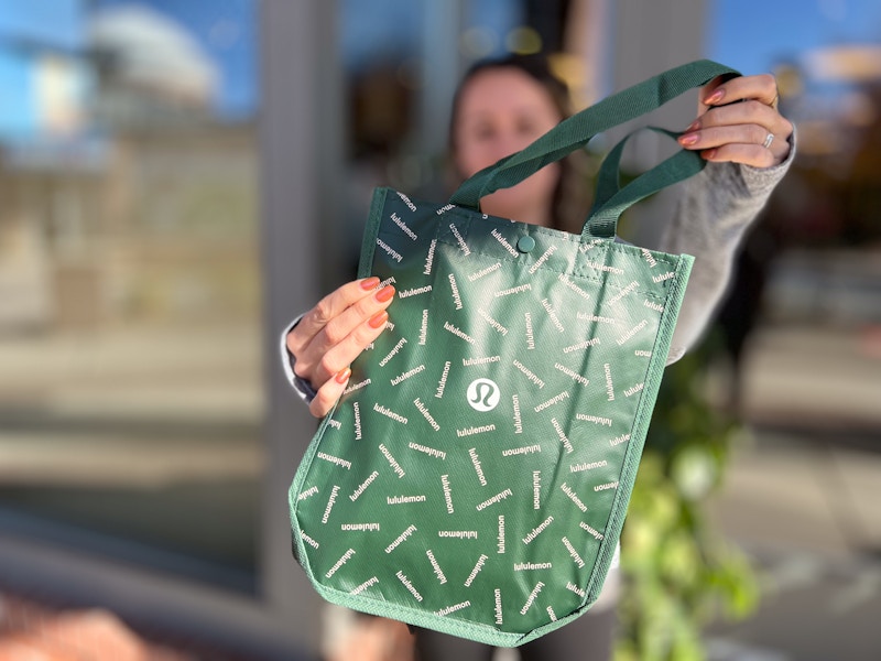 model holding lululemon bag outside of store