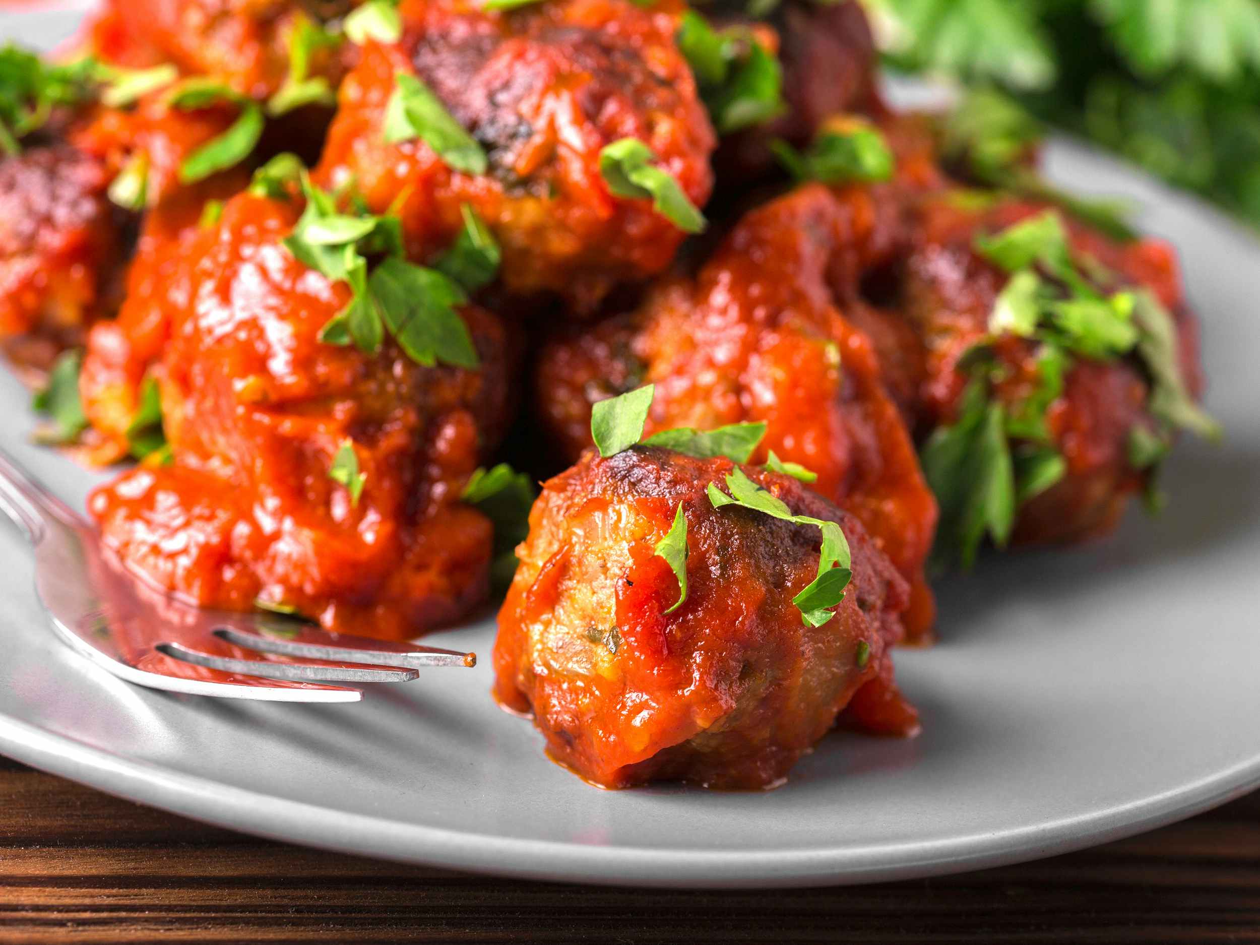 meatballs in marinara sauce and parsley on plate