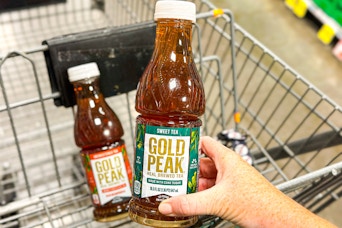 hand holding a bottle of gold peak tea