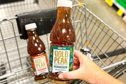 hand holding a bottle of gold peak tea