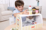 lifestyle image of a child playing with a melissa & doug ice cream playset