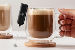a milk frother next to coffee
