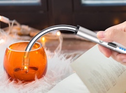 a hand lighting a candle with an arc candle lighter 