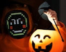 a kid with a LED mask holding a Halloween pumpkin bucket