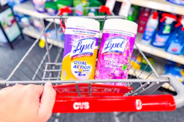 person pushing a cart with 2 containers of lysol wipes in it