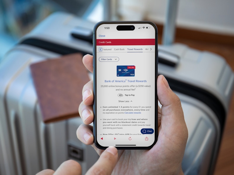 Someone looking at applying for a Bank of America travel rewards credit card in front of luggage