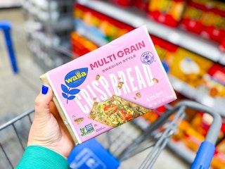hand holding a pack of wasa crispbread over walmart cart