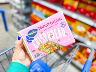 hand holding a pack of wasa crispbread over walmart cart