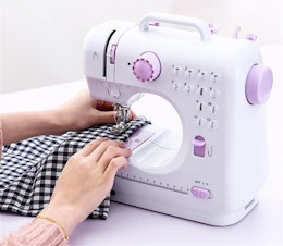 white sewing machine with purple controls