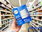 hand holding a box of the Febreze oil diffuser in a Walmart aisle