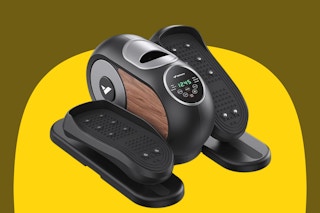 An under desk elliptical machine with wood-look trim and a digital display and controls in the middle of two moving foot pedals