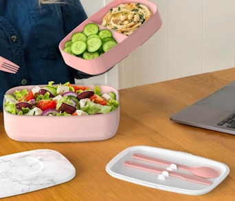 a person eating out of a pink bento box