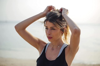 A woman wearing JBL wireless earbuds.