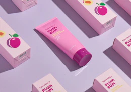 a pink tube of face serum on display with the packaging 