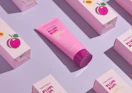 a pink tube of face serum on display with the packaging