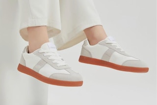 Woman wearing the UBFEN Womens Fashion Sneakers Classic Retro Trainers sitting down.