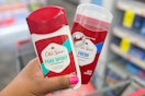 hand holding two Old Spice deodorants