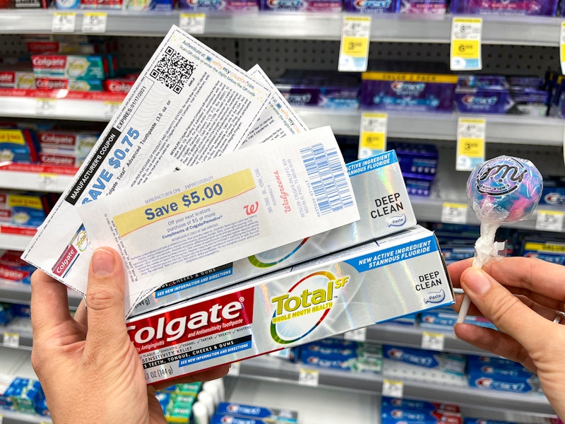 a person holding colgate toothpaste at walgreens 