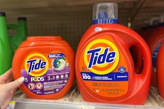 hand holding large tide pods next to large liquid detergent on store shelf
