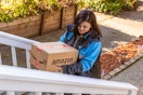 an amazon delivery driver walking up stair with a package