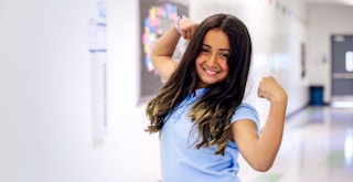 a child holding up their arms to show their muscles