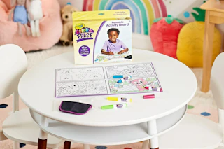 lifestyle image of a crayola color and erase board on a table in a kids playroom