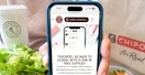 Someone holding up a phone displaying the web page for Chipotle's teacher contest