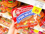 hand holding a pack of maruchan yakisoba noodles
