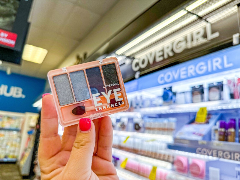 person holding a covergirl eyeshadow kit by the covergirl display