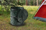 a collapsible trash can outside of a tent