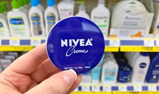 hand holding Nivea creme tin
