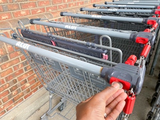 someone putting a quarter into an Aldi cart