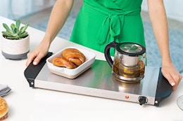 woman holding warming tray with breakfast items on it