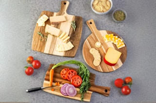 Classic Cuisine 3-Piece Acacia Wood Cutting Board Set used to cut different foods (lifestyle image)