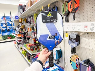 hand holding joola pickleball paddle in target sports aisle
