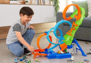 child playing with a Hot Wheels track