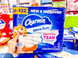 hand holding a pack of charmin toilet paper