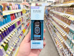 hand holding hask hair oil in walgreens